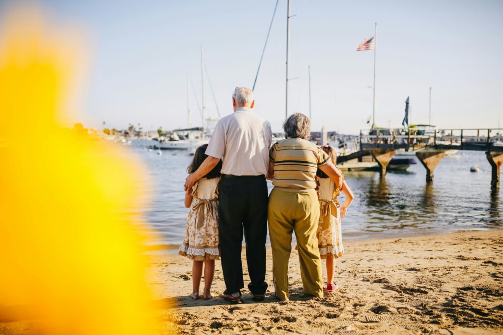 A multigenerational family enjoys a sunny day by the seaside, capturing togetherness and joy.