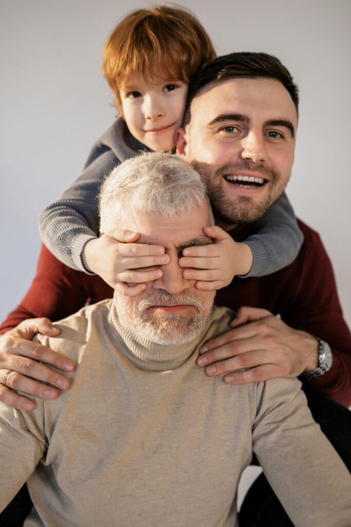 Joyful male family bonding, spanning three generations, with child, father, and grandfather.